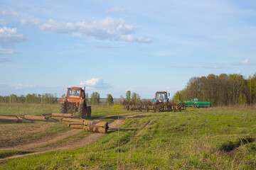 Fototapeta premium sowing works. three tractors. work on the field. harrow .