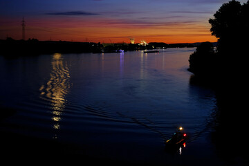 beautiful sea, river landscape with houses and a thermal power plant on the far bank of Wiesbaden in Germany, moon and is reflected in water, concept of water travel, water sports, transport