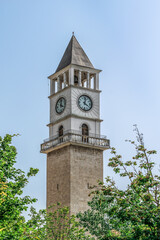 Clock Tower of Tirana against the blue sky in Albania. Square chapel in Islamic style among...