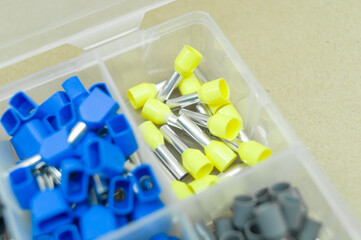 A set of colored crimp terminals for electrical wires. Crimping sleeves of different sizes. Plastic...