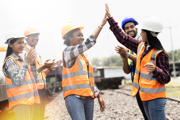 A group of young engineers are happily chatting at the machine work site at the railroad tracks.