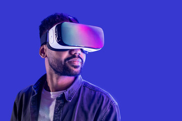 Serious young man using hi tech smart vr glassses isolated on blue background, Handsome men using...