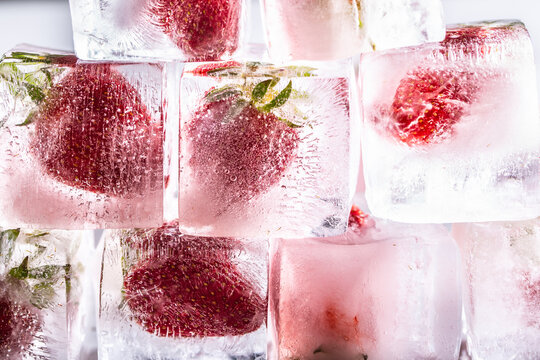 Fresh strawberries frozen in ice cubes - Close up.