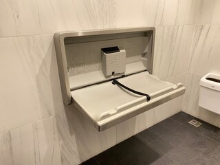 Baby diaper table in a public restroom. Child changing board in a toilet.