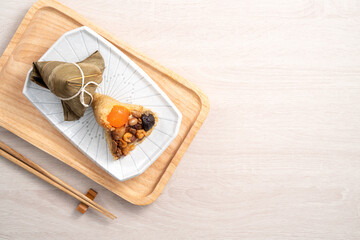 Zongzi. Rice dumpling for Dragon Boat Festival on bright wooden table background with ingredient.