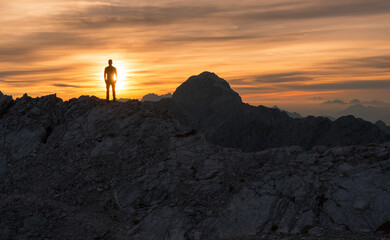 Male hiker at the top of the mountain at sunset