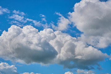Naklejka na ściany i meble Blue spring sky with big white clouds