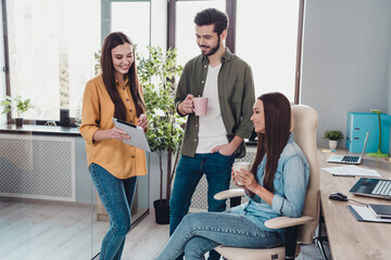 Portrait of three attractive experienced skilled cheerful people hr experts drinking discussing finance at work place station indoors