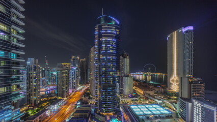 Fototapeta premium Panoramic view of the Dubai Marina and JBR area and the famous Ferris Wheel aerial night timelapse