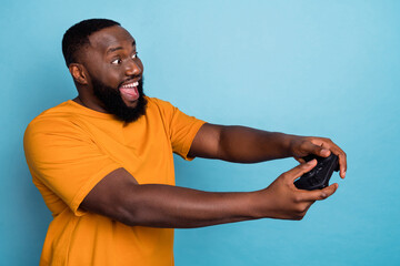 Profile side view portrait of attractive cheerful bearded guy playing game having fun isolated over...