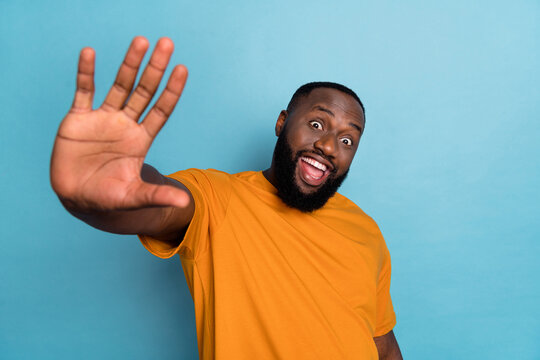 Photo Of Funky Funny Guy Dressed Orange T-shirt Waving You Arm Hello Isolated Blue Color Background