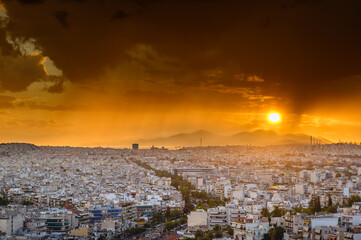 Panorama of the Greek capital Athens at sunset with a sky overcast with thunderclouds, Greece, Europe. View of the city from above.
