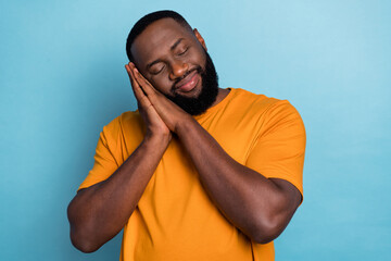 Photo of funny dreamy guy wear orange t-shirt arms cheek having rest isolated blue color background