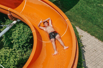 The guy swims in the pool and rides on the water slide. Children in an outdoor pool in Austria.