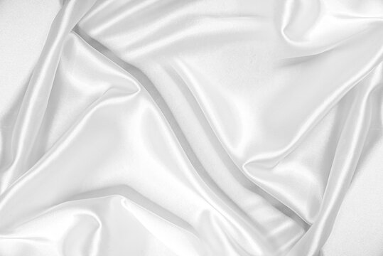 Closeup of rippled white silk fabric. White silk fabric as an abstract background.
