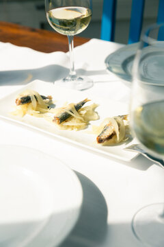 Venetian cicchetti sarde in saor with white wine Ribolla Gialla served at local bacari 