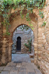 Fototapeta na wymiar Malaga, Spain, May 8, 2022: Nasrid arches in the interior corridors of the Alcazaba of Malaga. Palatial fortification from the Islamic era built in the 11th century