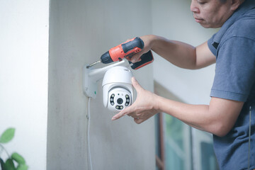 Man installing security camera CCTV wireless security equipment water proof cover to protect camera...
