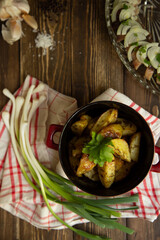 fried new potatoes with sauce and greens, with herring, tomato and green onion