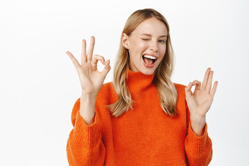 Okay, no problem, all perfect. Attractive smiling blond woman showing ok gesture and nod in approval, like and agree with smth, recommending, wearing winter sweater