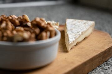 Portion of brie cheese with dried fruits and nuts. selective focus