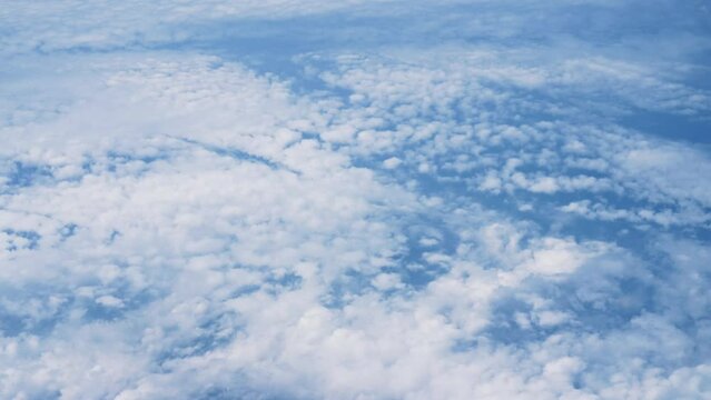 飛行機の窓から眺める空の景色　青空と流れる白い雲　4K　UHD
