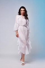Beautiful woman fashion model makeup brunette hair perfect body shape tanned skin wear clothes summer collection organic long white silk dress stylish sandals shoes, accessory jewelry earrings date.
