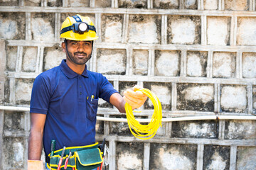 electrician holding bundle of wires staring by looking at camera - Concept of wire recommendation and promotion.