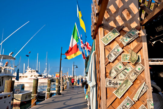 Dolllar bills on the wall in tourist seafront walkway in Key West