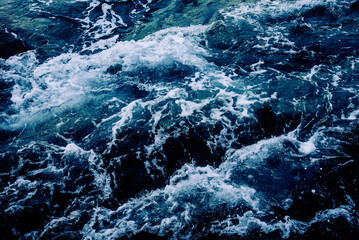 Dramatic sea waves storm from aerial view. Deep dark blue ocean water texture background. Top view. Fine art photography of stormy seascape from above. © hitdelight