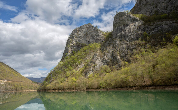 Cruise on the emerald waters of the Drina River with reflections and beautifully merging mountain ranges.
