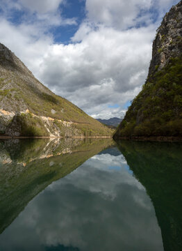 Cruise on the river with reflections. Two mountain ranges touch each other on the horizon.