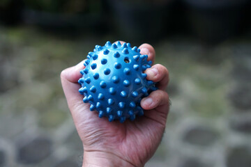 Male hand holds blue stress relief ball