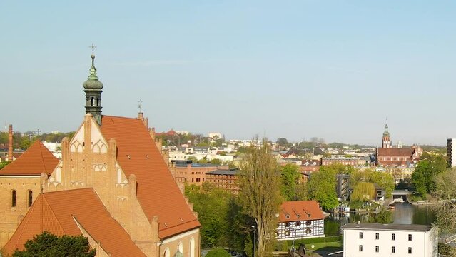 Sunny Day Over The City Of Bydgoszcz In Poland. Flock Of Birds Flying And Brick Gothic Bydgoszcz Cathedral In View. drone shot