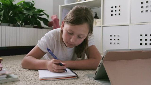 a girl with a tablet does her homework