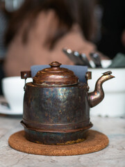 Antique copper teapot on the table served for breakfast