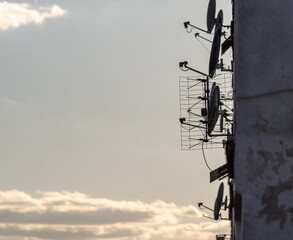 dużo anten telewizyjnych i satelitarnych na ścianie budynku