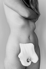 Cuerpo desnudo de una chica joven tapado por una bonita flor blanca