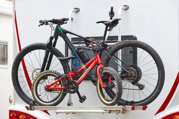 Fototapeta premium Bikes hanging on an recreational vehicle. Caravaning lifestyle