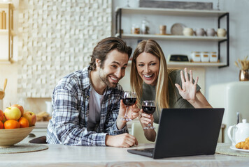 Happy surprised european millennial man with stubble and blonde lady with glasses of wine waving...