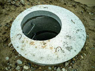 Dug-in concrete well rings with a concrete cover. Plumbing and sewerage.