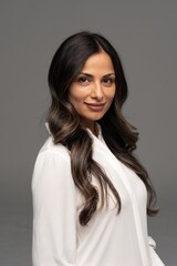 Studio headshot of beautiful Asian Indian woman in white blouse. 