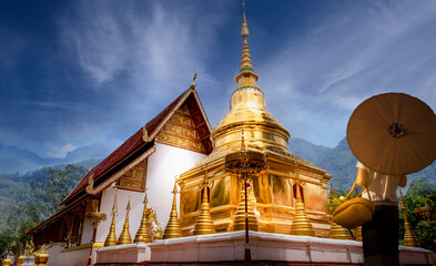 Naklejka premium Beautiful golden pagoda and temple with Thai Buddhist woman at the north of Thailand.