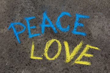 PEACE, LOVE inscription. Chalk drawing on sidewalk. The inscription in the colors of the Ukrainian flag