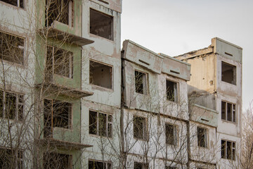 Dilapidated residential building with empty windows, collapsed roof, collapsed roof.