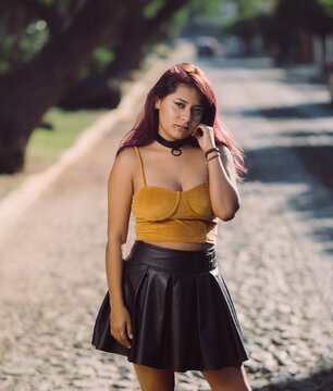 Latin Woman In Sexy Orange Tank Top With A Black Leather Dress 