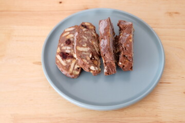 Homemade mosaic chocolate biscuit cake served in a blue plate, selective focus. It is called "Mozaik Pasta" in Turkish. That is texture of it not grain. Traditional Turkish dessert.