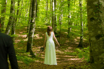 Bride in white dress walking through the spring forest in La Fageda d en Jorda, La Garrotxa, Spain