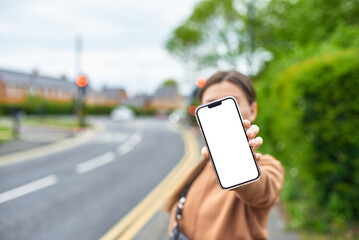 The girl holds a smartphone with a white screen for the logo against the background of a green...