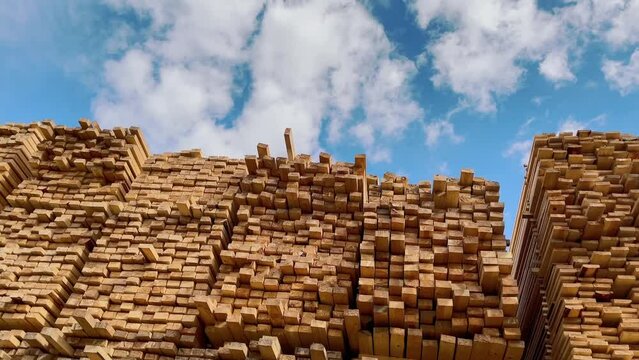 Wooden boards, lumber, industrial wood, timber. Pine wood timber stack of natural rough wooden boards on building site. Industrial timber building materials